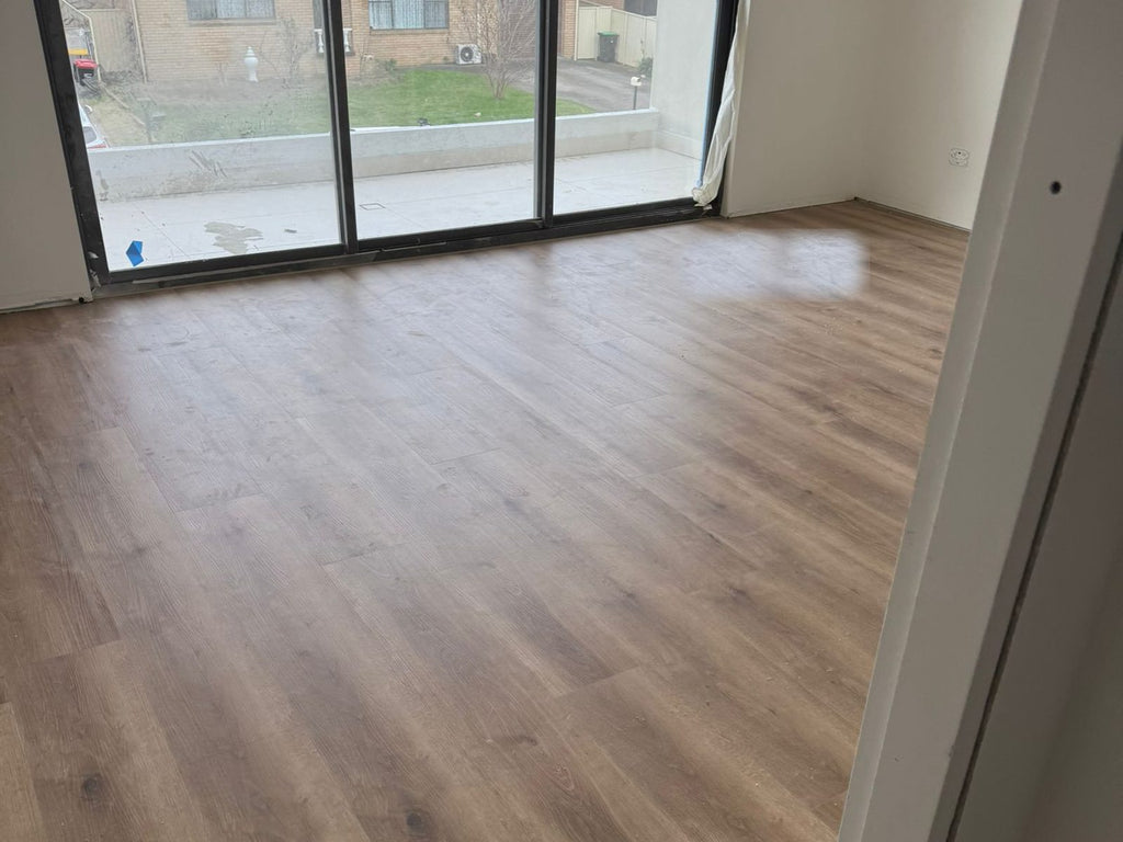 Living room finished in a grey-brown timber-look plank floor