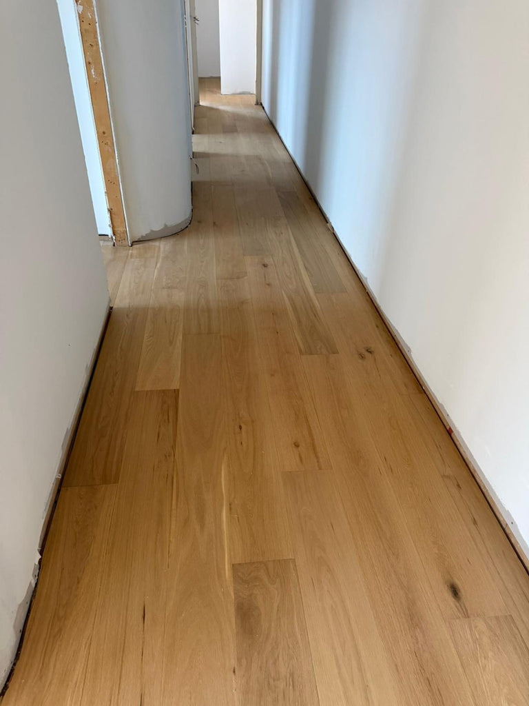 Hallway finished in warm oak wide boards, laid by Adore