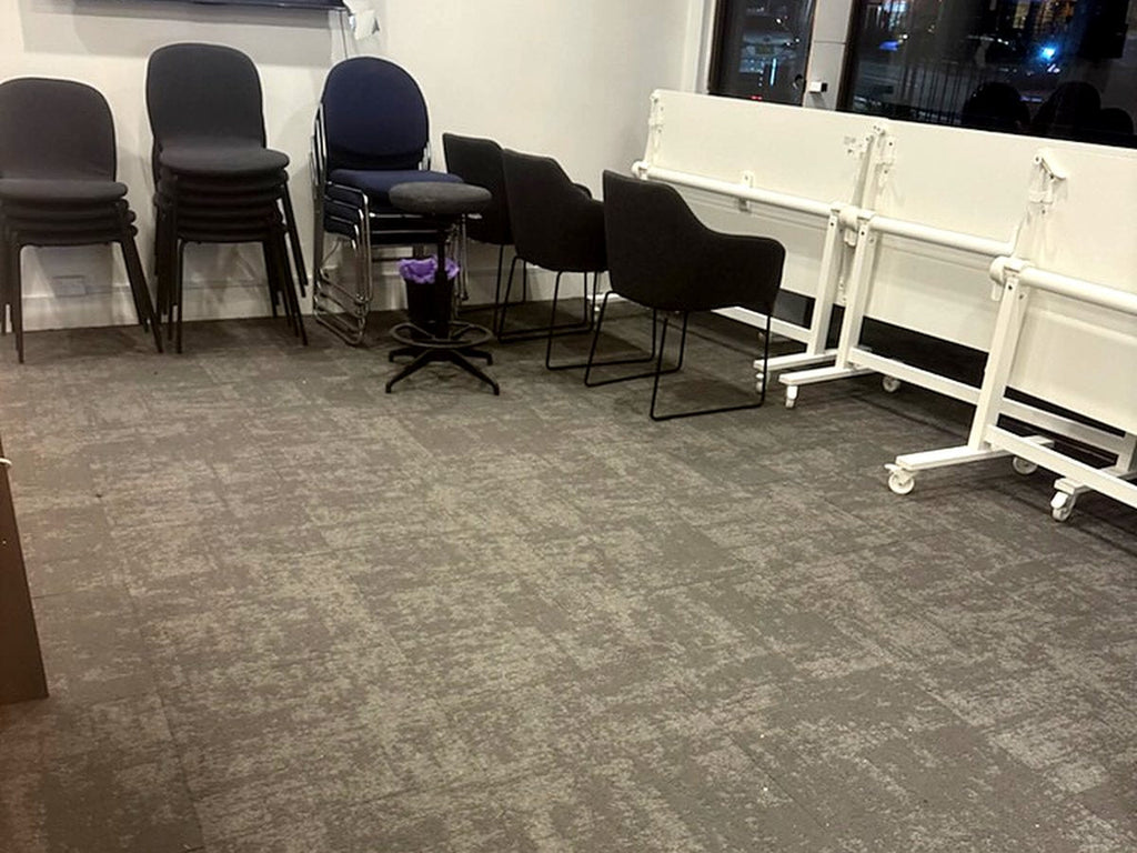 Grey carpet tiles laid in an office with desks and chairs