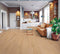 Lounge with a tan leather sofa on a pale pinkish blonde floor of wide timber boards
