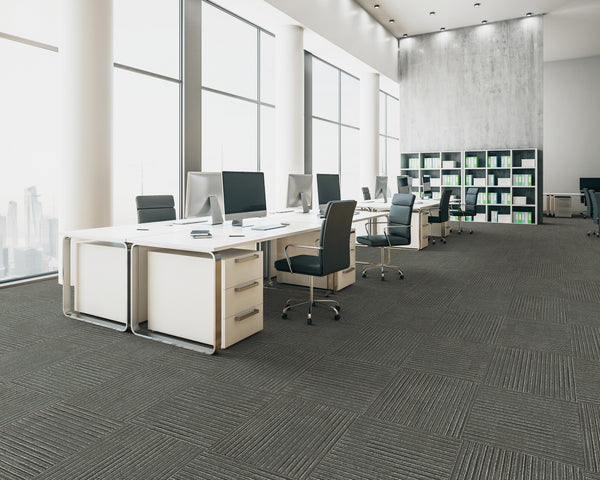 Office floor of mid grey carpet tiles with lighter stripes laid in a quarter turn chequer