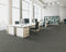 Office floor of mid grey carpet tiles with lighter stripes laid in a quarter turn chequer