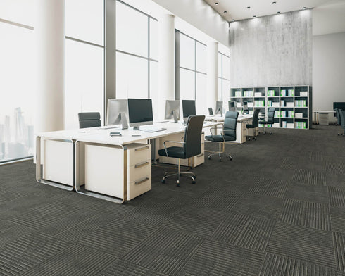 Office floor of dark grey carpet tiles with light grey stripes in a quarter turn pattern