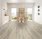 A pale grey-beige hybrid plank floor with cathedral grain in a dining room with timber chairs