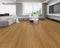 Lounge room laid with warm amber honey vinyl plank flooring