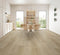 A light greige hybrid plank floor with a sandy tone in a dining room with timber chairs
