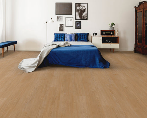 A light to mid warm tan hybrid plank floor with a pinkish beige tone in a bedroom with a blue bedspread
