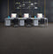 Office floor of dark charcoal carpet tiles with brownish-taupe streaks