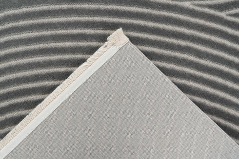 Grey rug with a unique pattern of concentric circles and curved lines, offering a sleek and stylish addition to any room