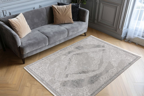 Decorative rug with elaborate gray and white motifs, including paisley and floral elements