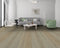 Lounge with a grey sofa and green chair on a cool grey-beige oak floor