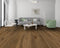 Lounge with a grey sofa and green chair on a warm mid to dark brown oak floor