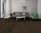 Lounge with a grey sofa and green chair on a very dark espresso brown oak floor