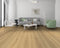 Lounge with a grey sofa and green chair on a light sandy beige oak floor with a honey tone