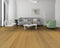 Lounge with a grey sofa and green chair on a mid golden honey-brown oak floor