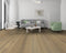 Lounge with a grey sofa and green chair on a muted grey-brown oak floor