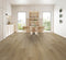 A light to mid warm tan-beige hybrid plank floor with knots in a dining room with timber chairs