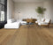 Living room with a white sofa on a warm golden brown oak floor showing cathedral grain