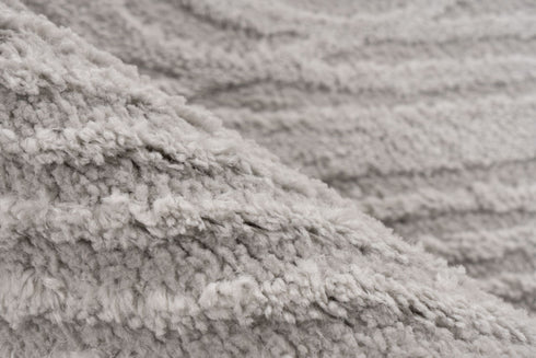 Plush area rug featuring soft curved lines and neutral tones