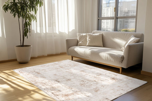 Antique-style rug featuring faded motifs and warm neutral tones