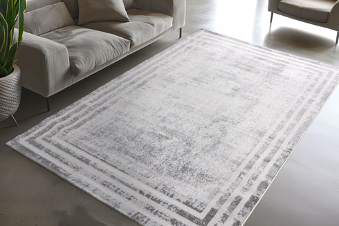 Faded rectangular rug featuring layered border design