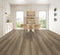 A smoky grey-brown taupe hybrid plank floor with dark streaks in a dining room with timber chairs