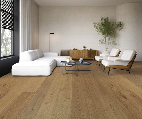 Living room with a white sofa on a warm golden brown oak floor showing cathedral grain