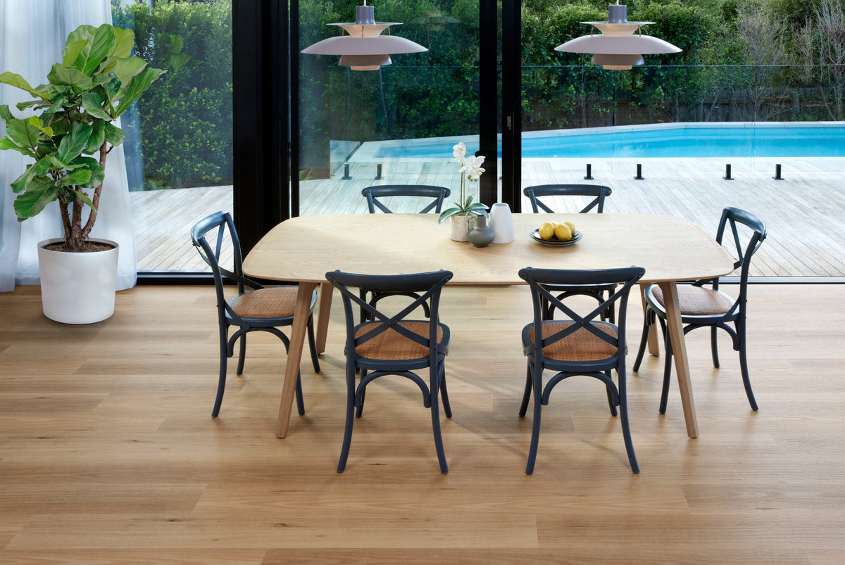 Timber-look floor in an open dining room with a pool view